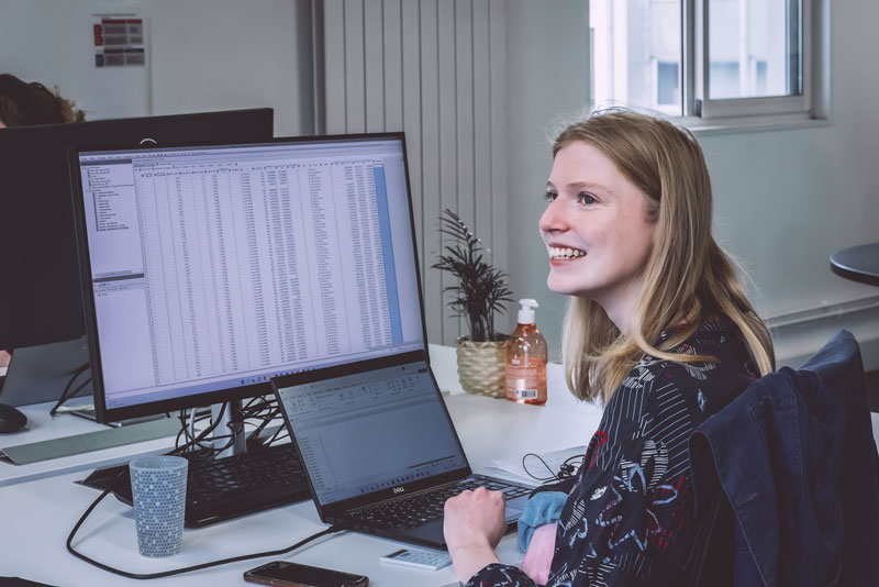 Une dame devant un grand écran présentant l'engagement social et environnemental de Veltys
